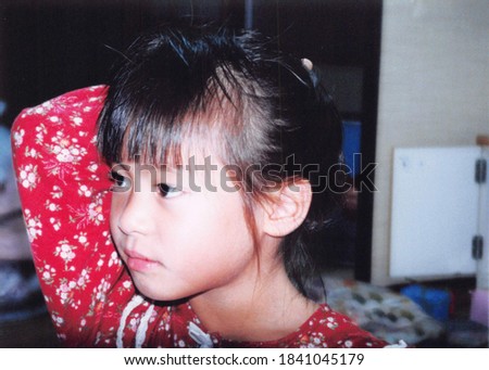 a little girl holding her hair