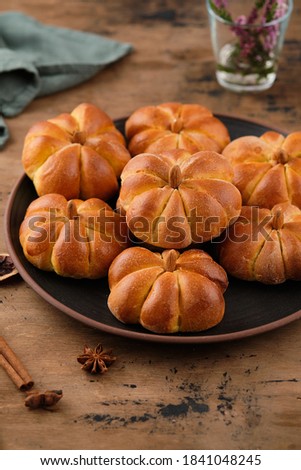 Pumpkin buns bread with spices on brown background. Halloween Food Concept. Autumn concept.
