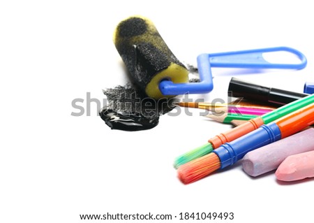 Sponge roller, black paint, dye for home renovation with colorful paintbrush set, felt pen marker and chalks isolated on white background