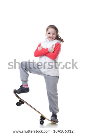 Cheerful little skateboarder posing with thumbs up