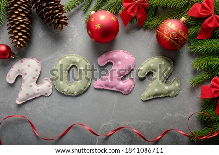 Stitched polkadot fabric digits of 2 0 2 2 with Christmas decorations aside flat lay on stone background