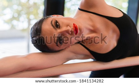 dancer is doing posing in dance class with ballet barre