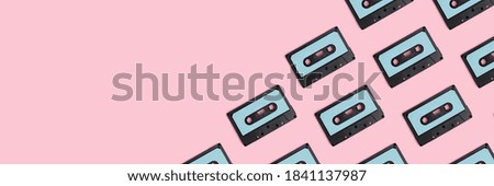 Cassette tapes pattern on a pink pastel background. Creative banner with place for text.