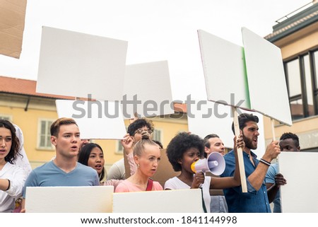 Public demonstration on the street against social problems and human rights. Group of multiethnic people making public protest