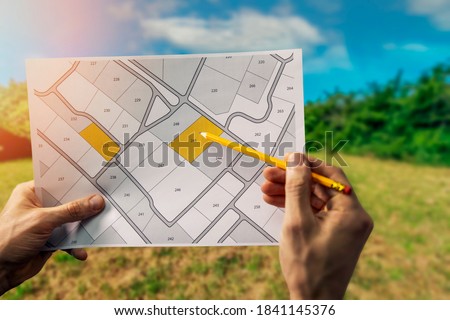 sale of building plot of land for house construction. cadastral map on field background Royalty-Free Stock Photo #1841145376
