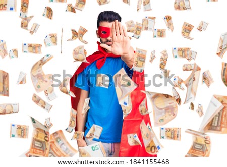 Young handsome man with beard wearing super hero costume doing stop sing with palm of the hand. warning expression with negative and serious gesture on the face.
