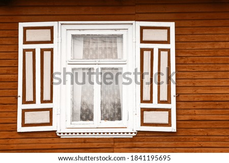 Wooden window rustic cottage house. Vintage wall with transparent glass window and decorative brown and white shutter. Countryside architecture background.