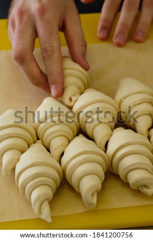 Close-up picture of french delicious croissants on the shelves in bakery. Making of process