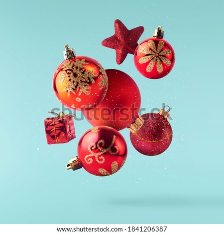 Christmas holliday card. Flyingin air red christmas decoration isolated on turquoise background
