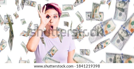 Young beautiful woman with pink hair wearing casual clothes doing ok gesture shocked with surprised face, eye looking through fingers. unbelieving expression.