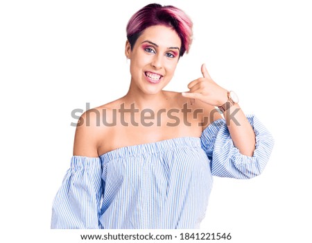 Young beautiful woman with pink hair wearing casual clothes smiling doing phone gesture with hand and fingers like talking on the telephone. communicating concepts. 