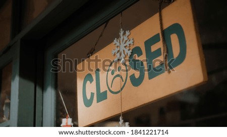 A sign hanging on the door of the institution with a glass window with the inscription closed with sad smile