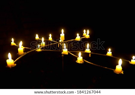 candles in the dark on a stand indoors             