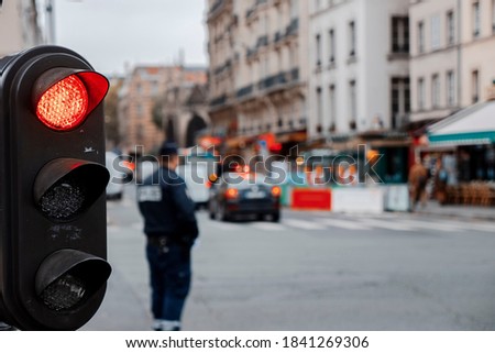 vintage black traffic red light in paris depth of field police and cars