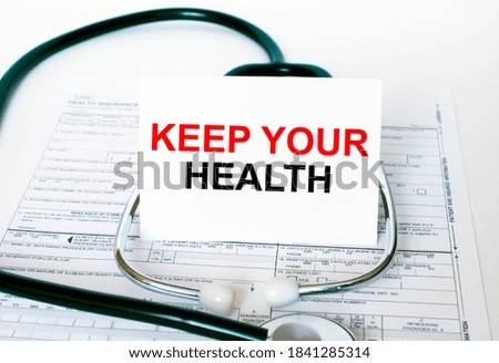 Text Keep Your Health on the white card with the stethoscope and medical documents. Medical concept photo