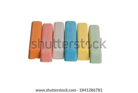 colored crayons lie in one row on a white isolated background