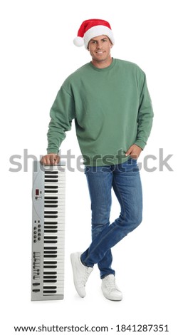 Man in Santa hat with synthesizer on white background. Christmas music