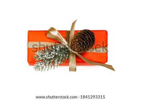 Gift box with golden ribbon, bow and fir cone isolated  on white background. Party time concept. Flat lay.