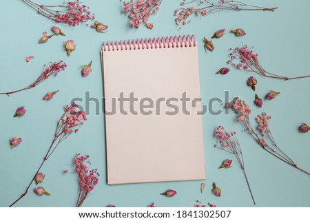 Spring minimal concept. pink flowers flat lay. Blank white notepad. Women's Day. View from above