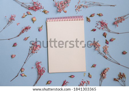 Spring minimal concept. pink flowers flat lay. Blank white notepad. Women's Day. View from above