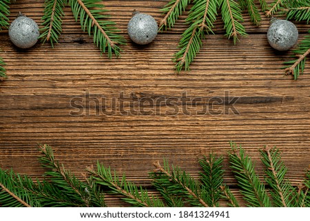 Fir, spruce branches and Christmas tree toys on brown wooden background