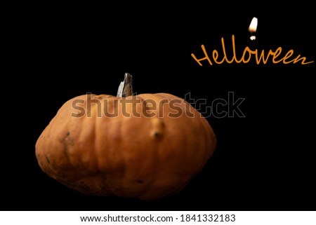Halloween. Pumpkin and candle on a black background,