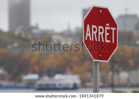 A stop sign in French, translation of Stop in English, with a view of the Chateau Frontenac in Quebec
