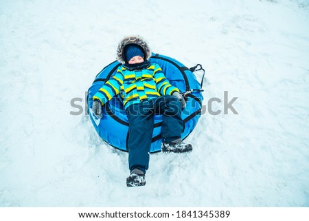 little kid in snow tube. winter time