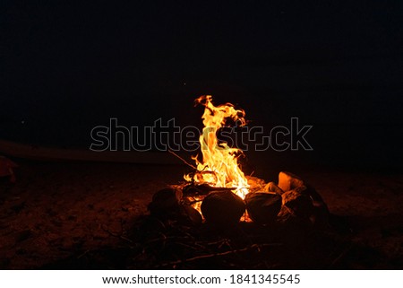 Bright bonfire with flames bursting up at night