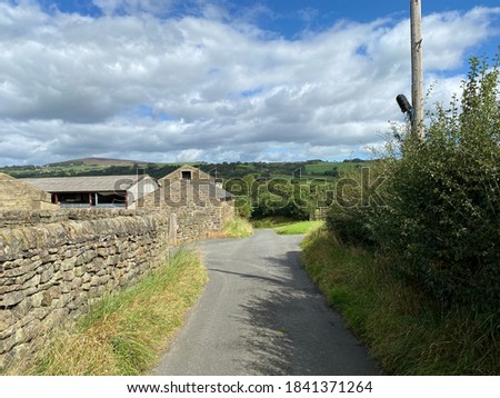 View down, Lumb Gill Lane, with dry stone walls, and farm outbuildings in, Addingham, Ilkley, UK
