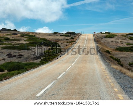 Two-way uphill road with end in the blue sky