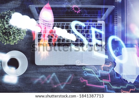 Double exposure of SEO drawing over study table background with computer. Concept of search. Top view.