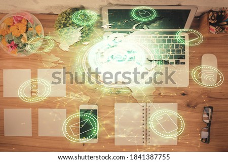 Social network hologram drawings over computer on the desktop background. Top view. Double exposure.