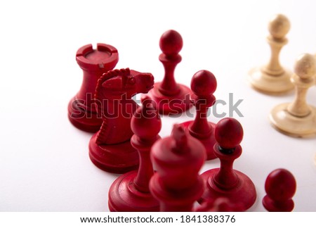 A red and white chess set made from bone on a white background