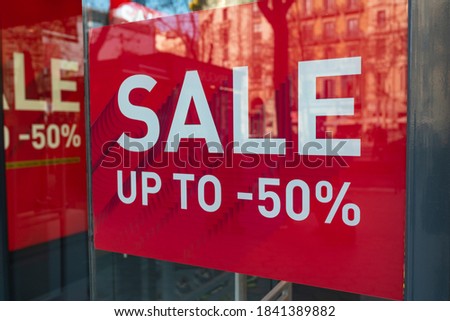 Red sale sign 50% in a street shop window.