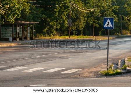  zebra crossings crosswalk with traffic sign "pedestrian crossing" on an empty road