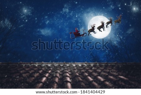 Santa Claus on his sleigh, pulled by reindeer, flying at night to deliver gifts