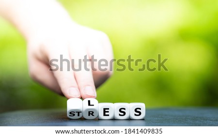 Symbol for less stress. Hand turns dice and changes the word "stress" to "less".