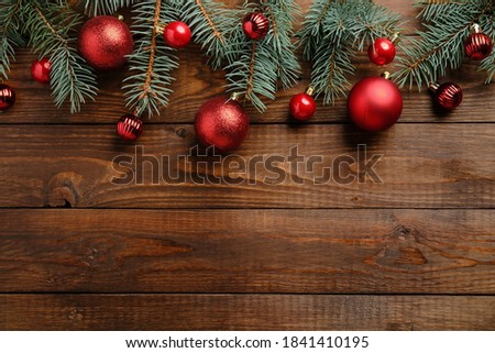 Wooden Christmas background with red baubles decoration and fir tree branches.Christmas holiday celebration, winter, New Year concept. Christmas banner mockup, greeting card template