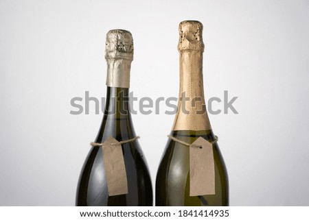 Champagne bottles with hand labels on a light background. Horizontal orientation. The concept of festive drinks.