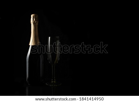 Champagne on a black background with space to copy. Side view. Concept of alcoholic beverages.