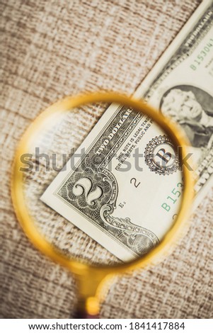 Rare two-dollar bill under a magnifying glass of a lupe - the number two is enlarged