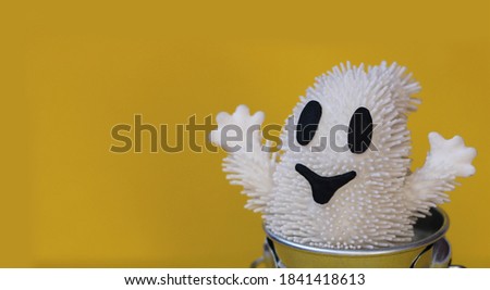 Halloween white ghost in a bucket, on a yellow background, halloween template design, isolated, close up
