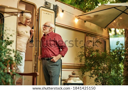 Beautiful senior lady talking with her husband near their motorhome