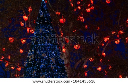 night festive street Christmas tree decoration and garland lighting red and blue color on branches soft focus and noise polluted concept picture  
