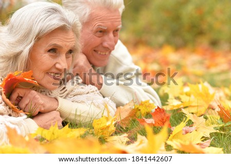 Portrait of a cute senior beautiful woman lying on leaves