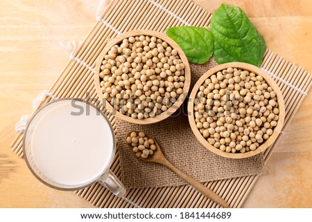 Soy milk in the glass and soy beans on wooden background, Top view