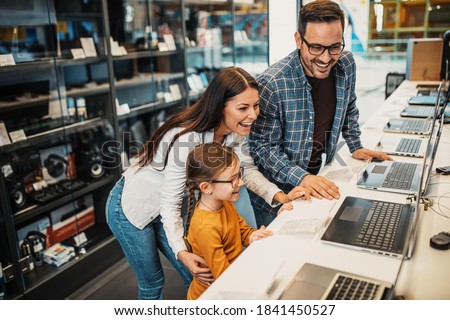 Happy family buying laptop in store. Royalty-Free Stock Photo #1841450527