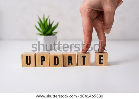 Update message sign on a desk in a room with a white background.