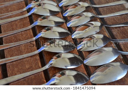 the collection of metal spoons on the wooden table is very exotic and classic